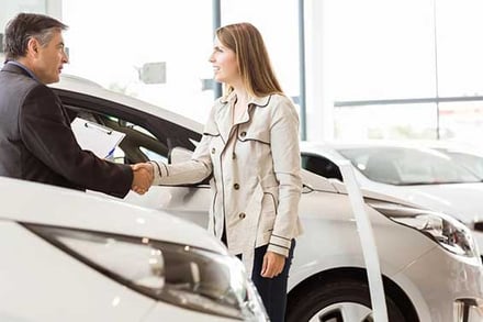 Salesman-shaking-hand-of-a-client-at-new-car-showroom